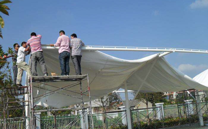 五個人正在高空安裝膜結(jié)構(gòu)膜布